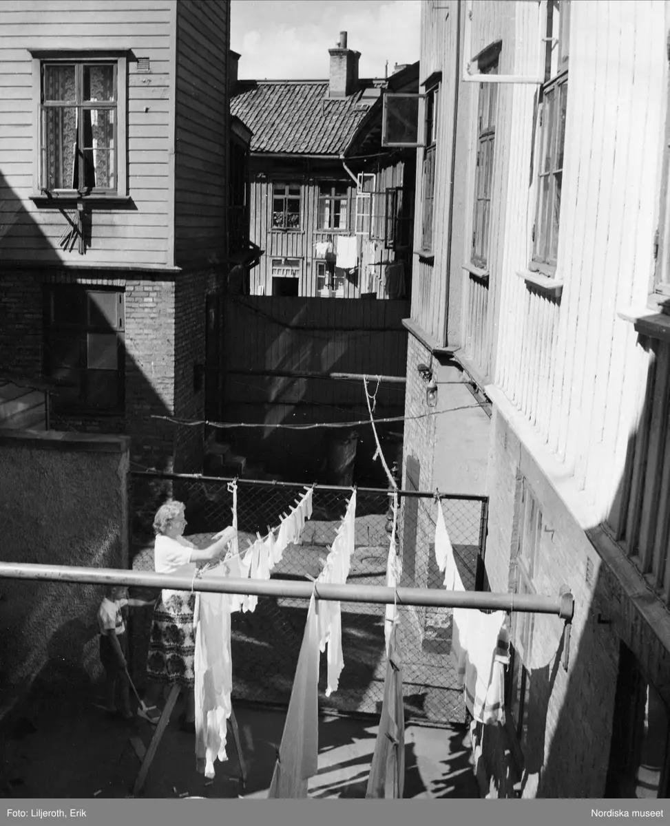 Göteborg. En kvinna hänger upp tvätt på en bakgård