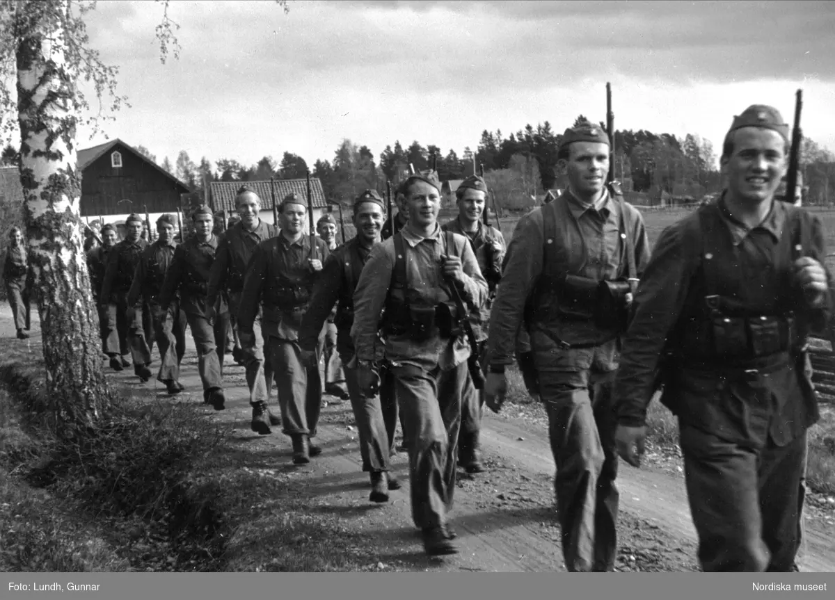 Militär beredskap, andra världskriget. Män med vapen, svenskt infanteri, marscherar på landsväg.