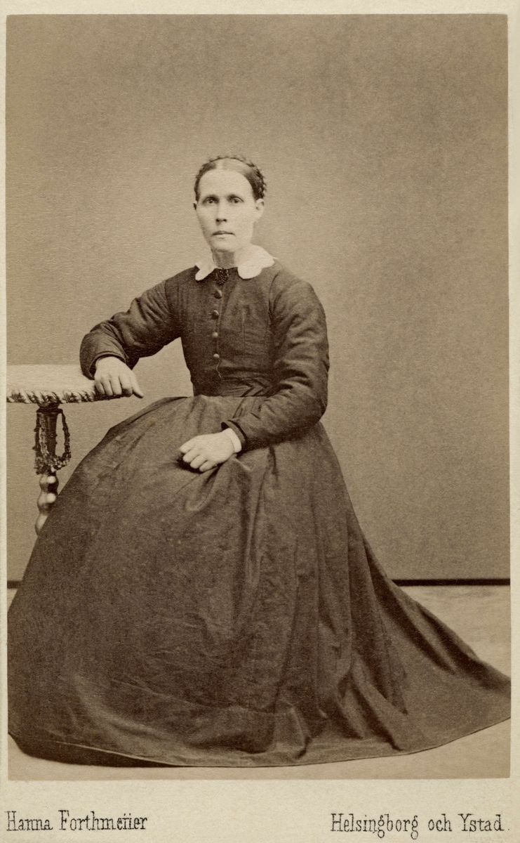 En kvinna poserar i en lång klänning