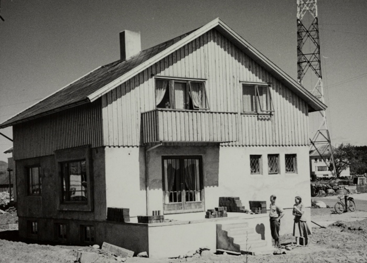 Enebolig, bygget av en selvbygger - Gunnar Nygård med kona foran huset