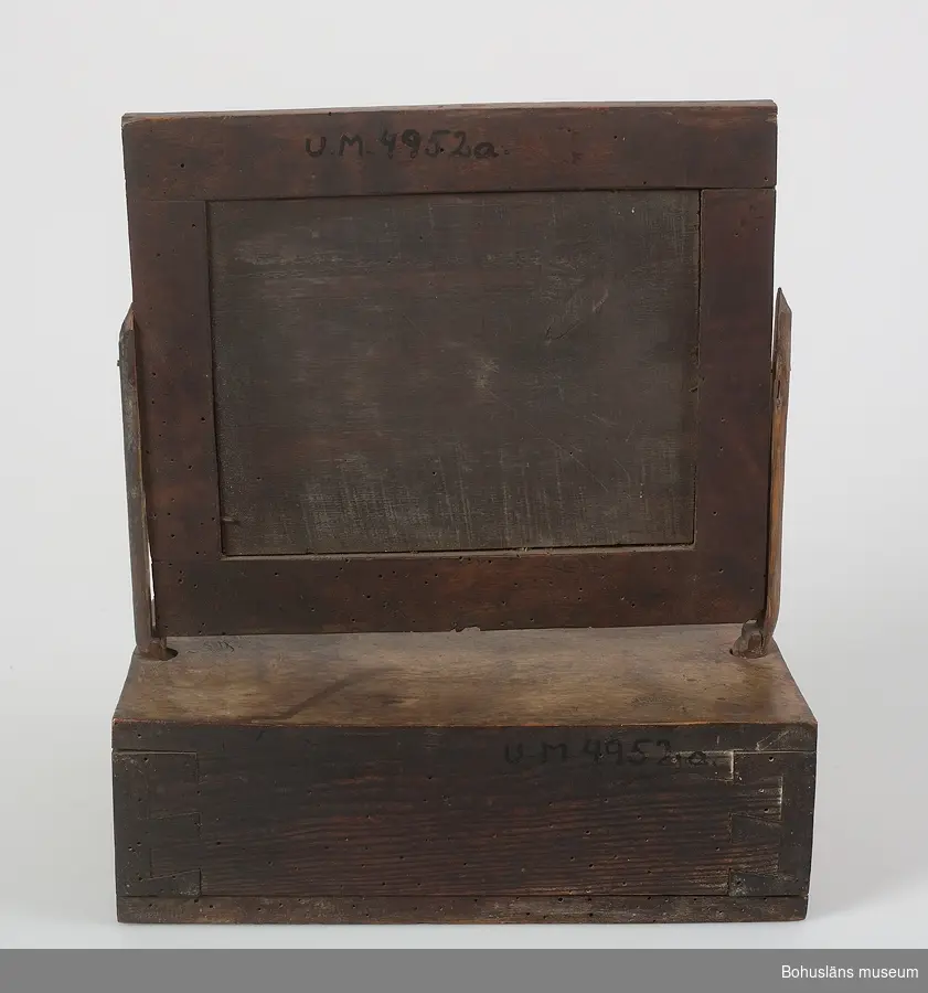 Ur handskrivna katalogen 1957-1958:
Rakspegel med låda
H.: 30 cm. Lådans mått: 19,2 x 15,5 x 5,4 cm. Spegelns mått (inkl. ram): 23,8 x 20,2 cm. Maskhål.

Lappkatalog: 94