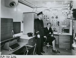 Mann og kvinne i radiorommet på cargolineren M/S Hørda (sene