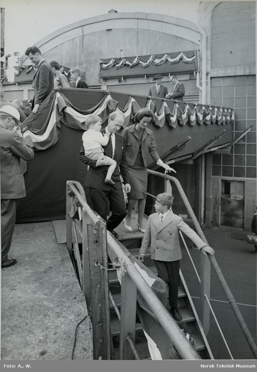 Fred. Olsen på vei ned fra tribunen sammen med to barn og en kvinne etter stabelavløpning av tankeren M/S Landvard, B/N 527 på Akers Mek. Verksted 14. juni 1962. Skipet ble levert i 1962 til Klosters Rederi.