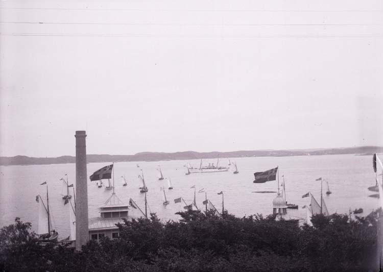 Vid H.M. Konung Oscar II ankomst till Lysekil. Kungajakten Drott efter ombyggnaden 1901. Segelbåtar. I förgrunden varmbadhuset.