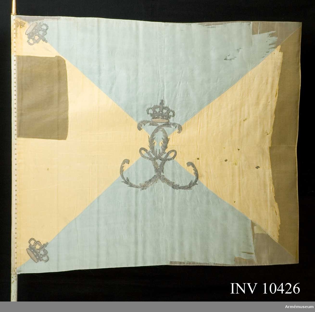 Duk av taft, fyrstyckad, blå och gul. I mitten Gustaf III:s namnchiffer.