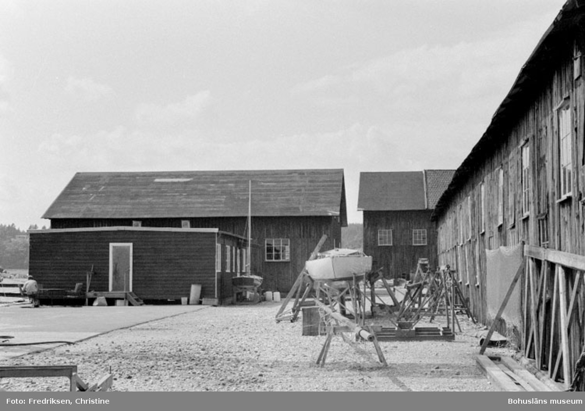 Motivbeskrivning: "Allmags varv, Allmag, Orust. Till höger i bild; byggnad för vinterförvaring av båtar (tidigare användning som bl.a båtbyggarverkstad, förmodligen uppförd i början av 1900-talet), där bakom annan byggnad för vinterförvaring av båtar (del av byggnad uppförd på 1920-talet). Till vänster nyare baracklänga för kontorsändamål, där bakom f.d. virkesmagasin uppförd på 1930-talet.
Datum: 19800710
Riktning: V