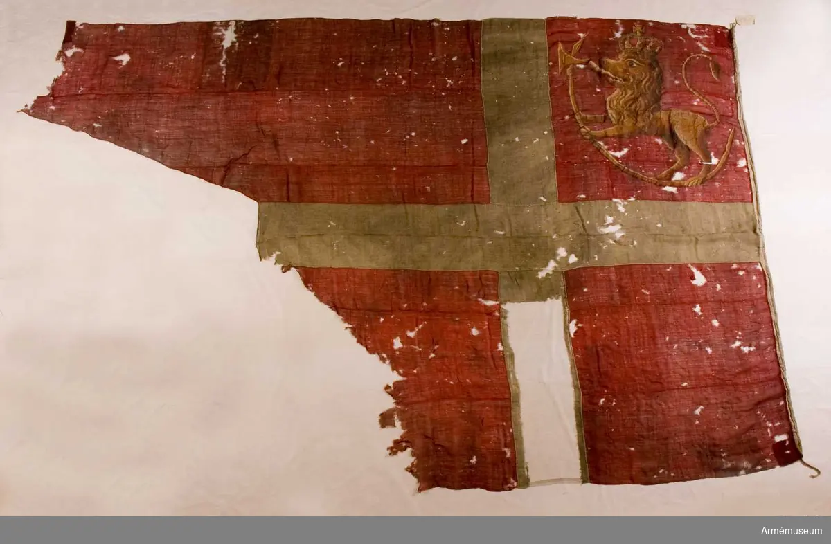 Flagga, troligen ursprungligen tvåtungad, av rött ylle med numera vitt kors i mitten. I övre, inre fältet ett målat norskt lejon med kunglig krona, stående på en krum hillebard.