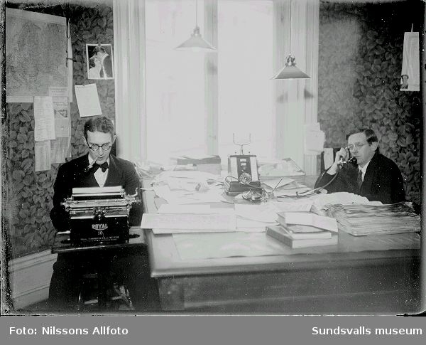 Interiör från ett kontor, män jobbar vid ett skrivbord.