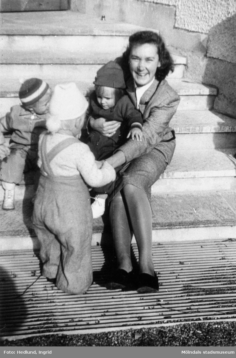 Fröken och några barn sittandes på en trappa vid ett daghem i Guldheden, Göteborg, 1940-tal.