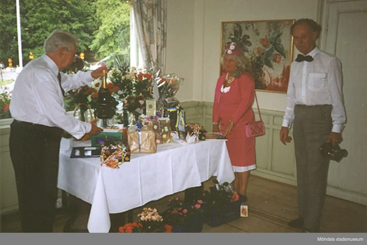 Margit Wennerbergs moster Brita firar sitt 85-årskalas den 12 augusti 1994. Från vänster: Gösta (Britas man) samt Margit och Lars Wannerberg. Margits klänning, jacka, hatt, handväska och skor finns i Mölndals stadsmuseums samlingar.