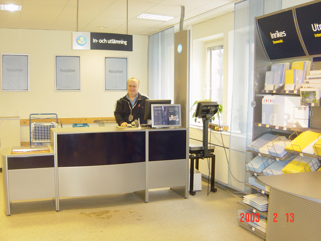 Postiljon Lennart Zamore vid disken på Postcenter i Kista, 2003. Nyhet i försäljningssortimentet är att "portot ingår i priset på alla kort, kuvert och kartonger".