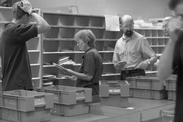 Posttjänstemän sorterar post inne i sorteringsdelen på en
postanstalt. Tillhör en dokumentation av en lantbrevbärare i trakten
av Valdermarsvik av fotograf Ove Kaneberg.