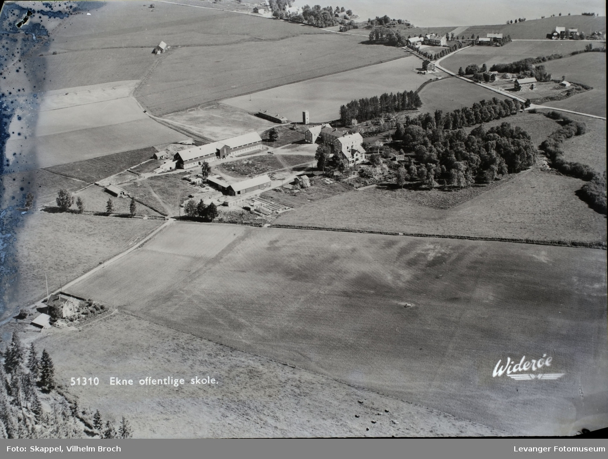 Fjellanger og Widerøe`s flyfoto av gård,gårdstun, åker og landskap.  Institusjonsbygning

