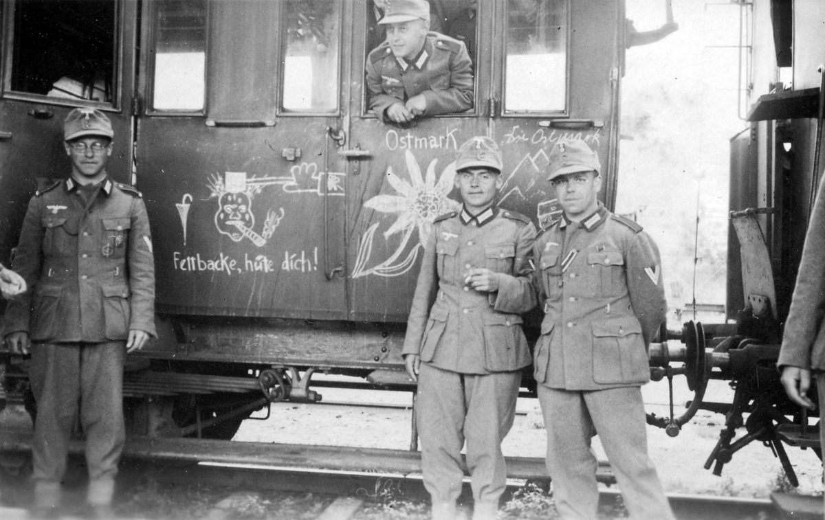 Tyske eller østerrikske soldater foran en jernbanevogn. Vognen er dekorert med edelweiss og en karikatur av W. Churchill.