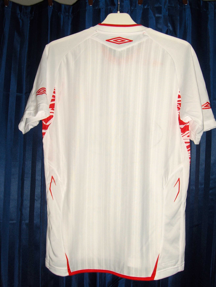Hvit fotballtrøye med røde kanter med signering av FFK-spillerne på front nedre del under sponsorlogoen til Carnegie.