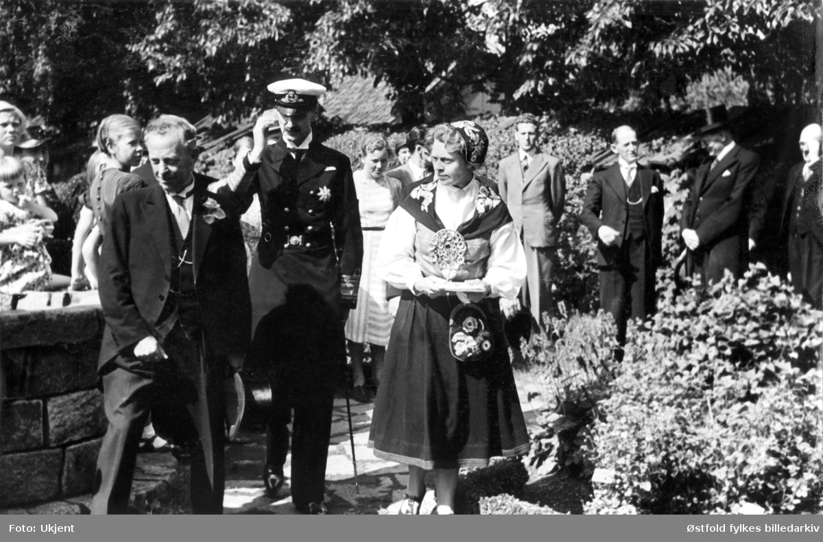 Kongebesøk på Borgarsysel Museum i Sarpsborg 9. august 1939.
Fra venstre stadsingeniør F. Wisløff, H.M. kong Haakon VII og fru generaldirektør Asta Meidell.
De ser på urtehagen.