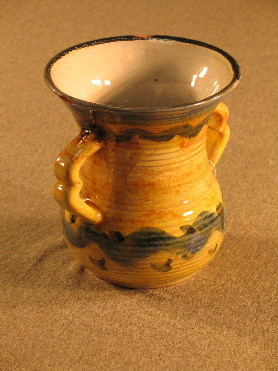 Vasen er timeglasforma med to hankar. 