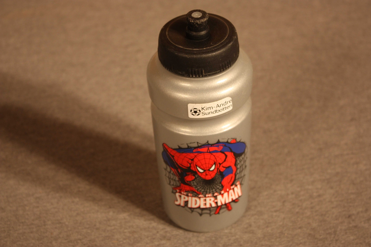 Plastflaske  med skrukork. Dekorert med teikning av Spider-man.
Brukt av born på skulen, turar m.m. På to stader er klistrelapp med namn Kim-Andre Sundbotten