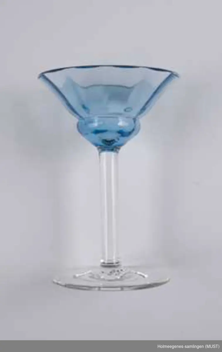 Fem Likørglass av kristallglass. Trolig utenlandsk, muligens Bohemen. De fem har fem ulike farger. Fargene og den åpne formen på klokken har Art Nouveaupreg. Glassene har fargene som var på moten mellom 1920 og 1930. Klokken har svake bølger. Stetten er høy og glatt. Glassene har ulik vekt: Stetten på det blå glasset er tykkere.
