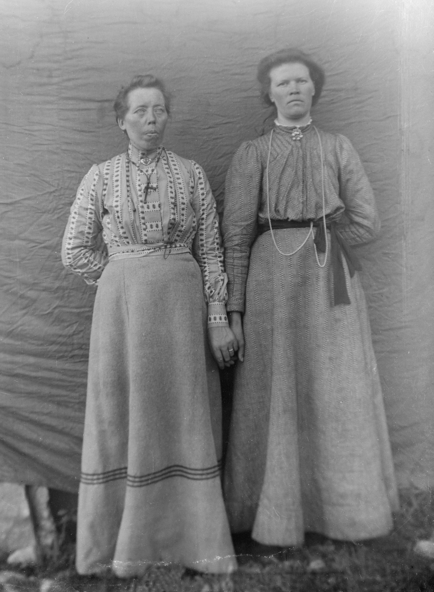 To kvinner i helfigur foran lerret, holder hverandre i hånda. Til venstre Ingebjørg Eltun, og til høyre Kirsti Kjærstein