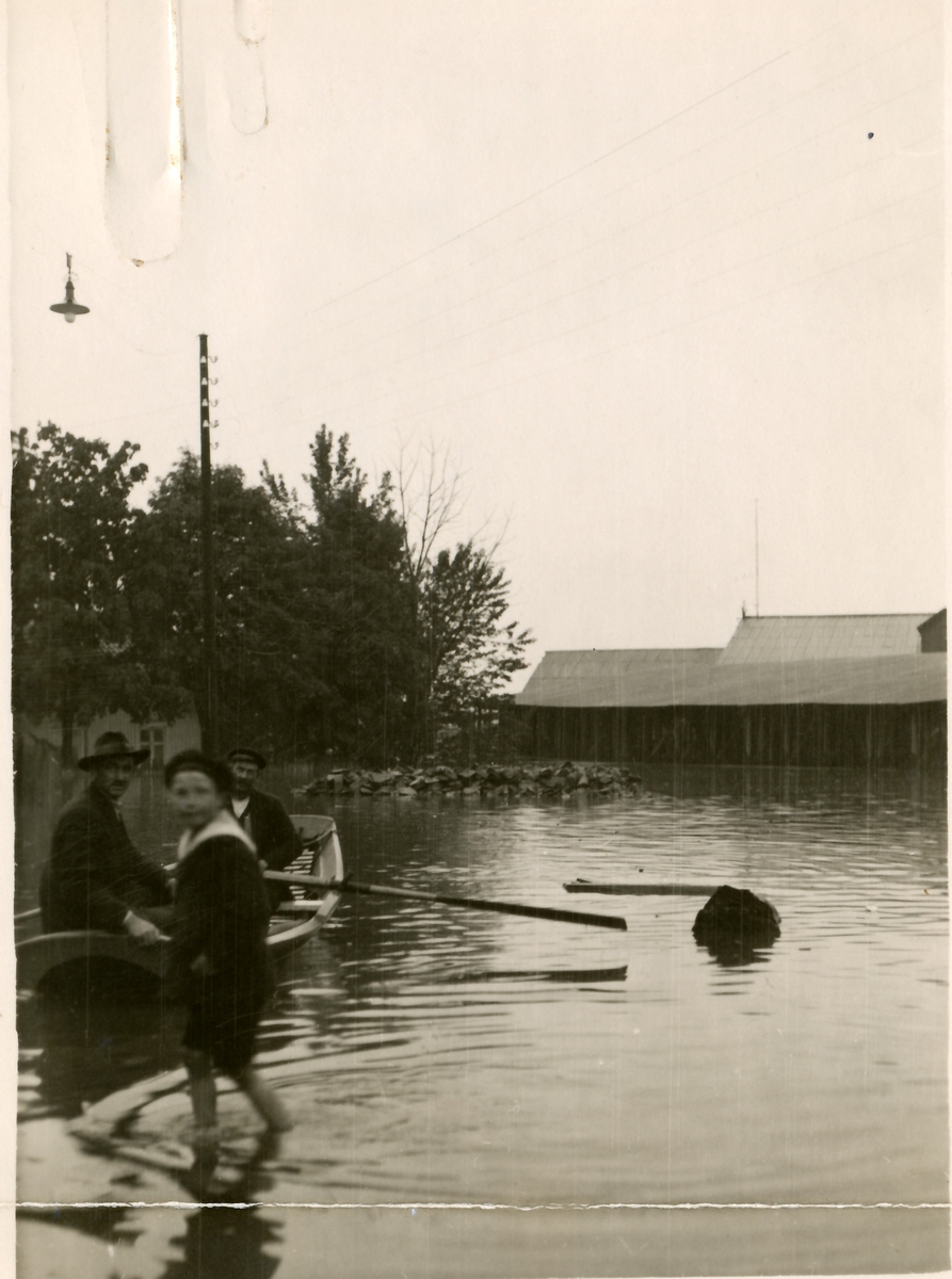 Flommen i Skien, 1927. Menn i robåt, gutt som vasser.