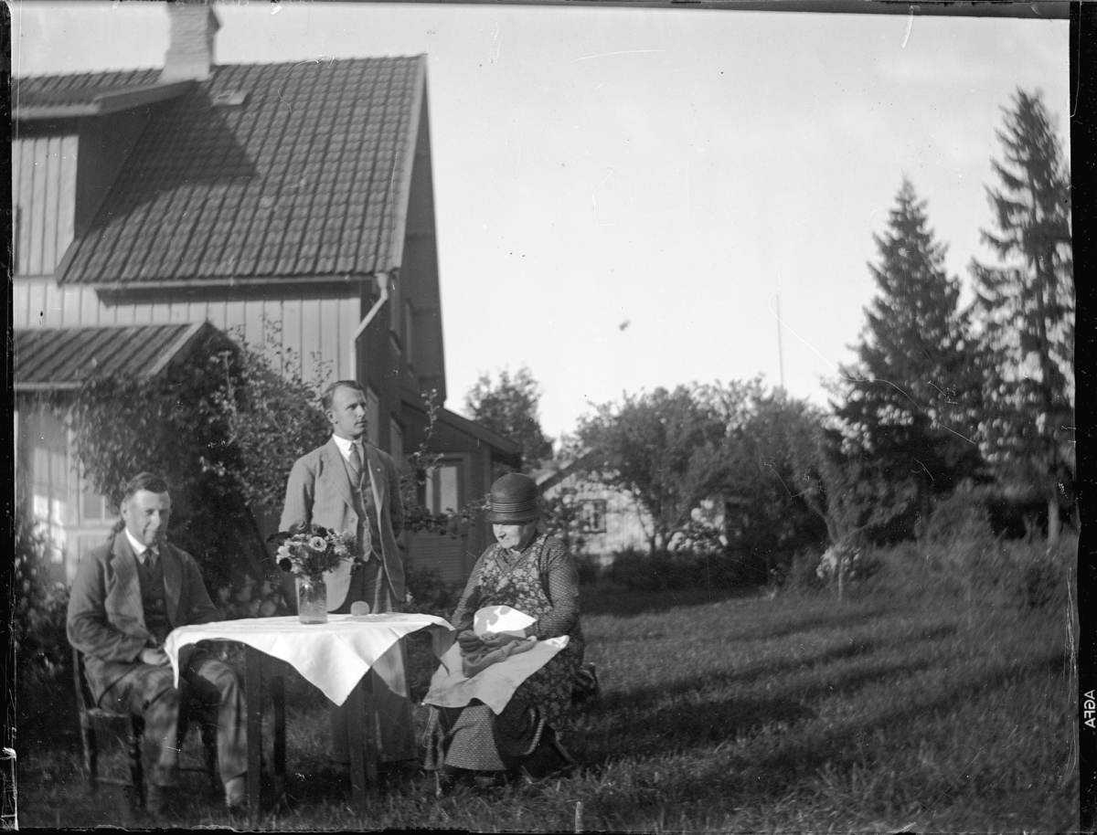 Vid ett bord i trädgården. Troligen i aug, 1931. Mamma, Anders och jag.