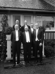 Menn i bryllupsselskap fotografert