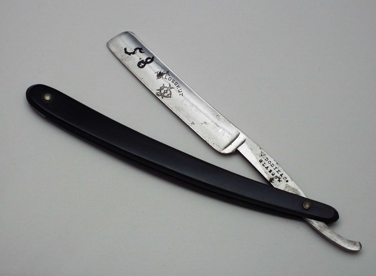 Barberkniv i stål med buet skaft i skilpaddeskall. Kniven er sammenleggbar.