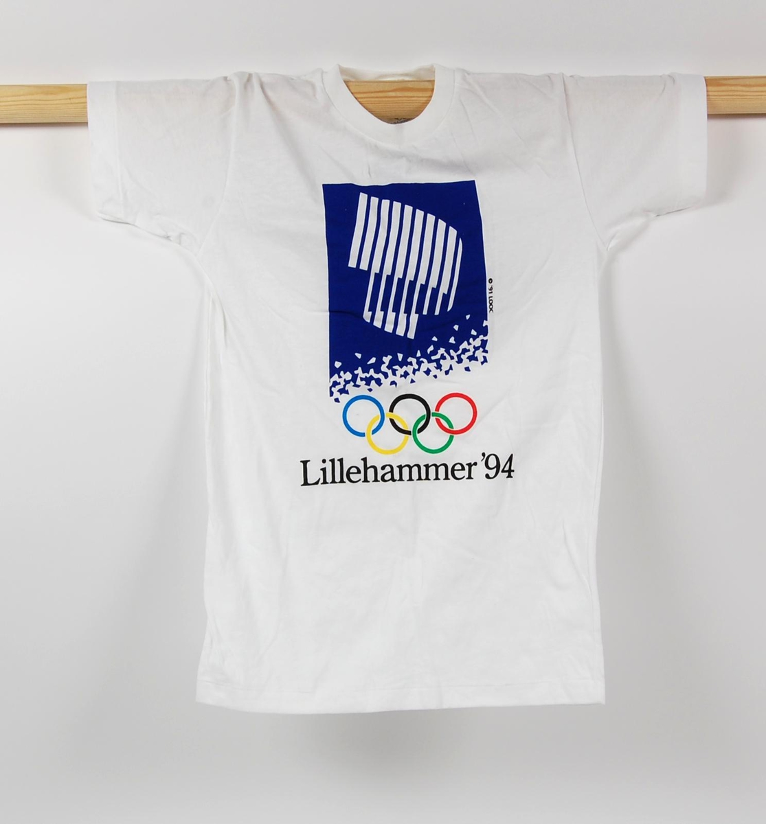 Hvit t-skjorte med flerfarget logo for de olympiske vinterleker på Lillehammer i 1994. T-skjorten er i barnestørrelse.