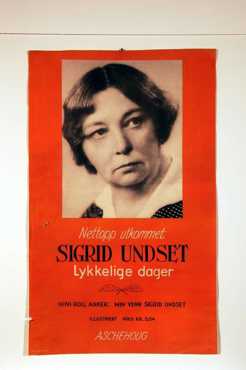 En plakat som reklamerer for S.U.s minnebok 'Lykkelige dager'. Plakaten har også et portrettfotografi av S.U..