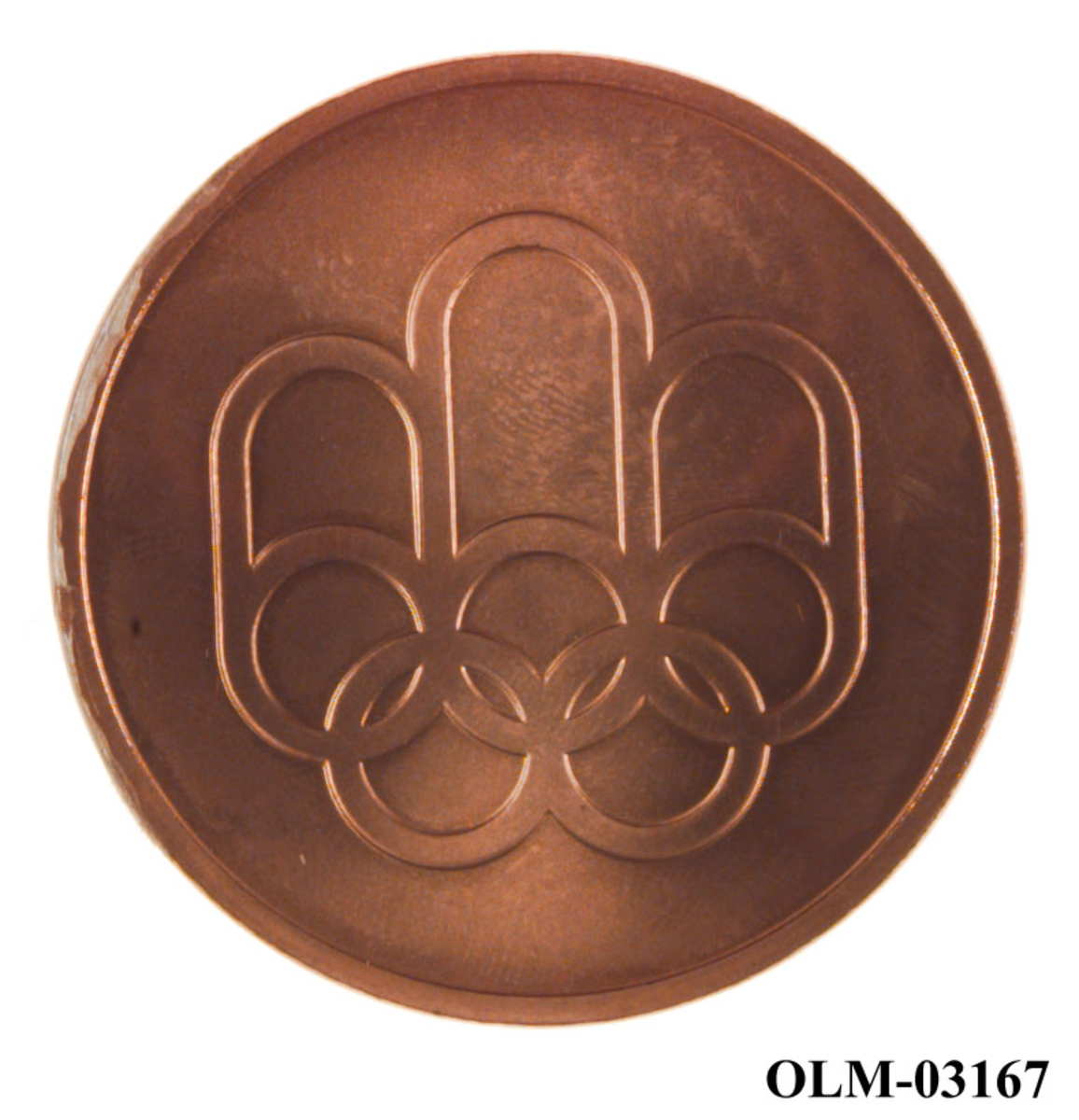 Bronsefarget minnemdalje med emblemet for de olympiske sommerleker i Montreal i 1976 og motiv av den olympiske stadion i Montreal. Med medaljen følger det et sort etui.