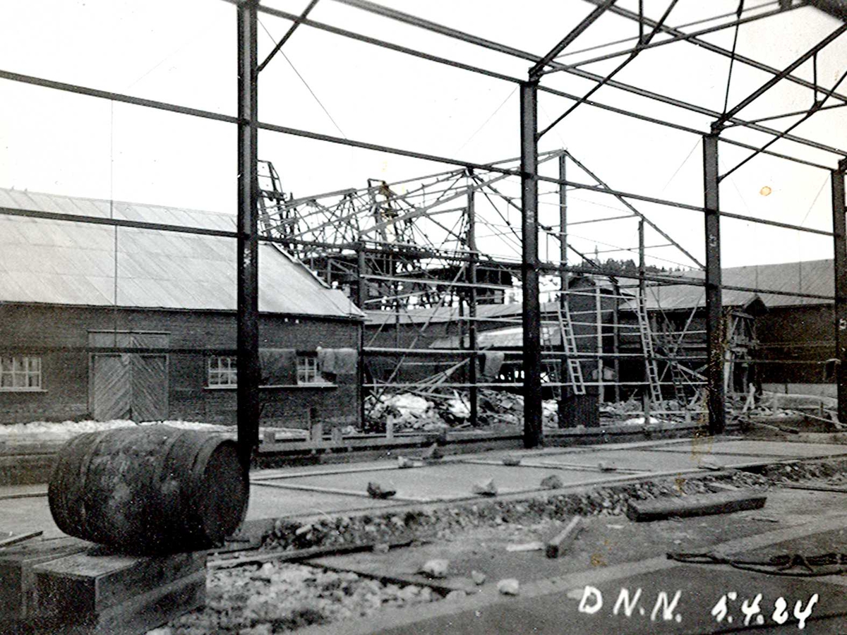"05/04-1924" Nitriden. Stekeribygning for steking av elektrodekull under bygging. Jernkonstruksjoner. Tjæretønne og lagerbygning til venstre. To kraner på kai sees i bakgrunnen.