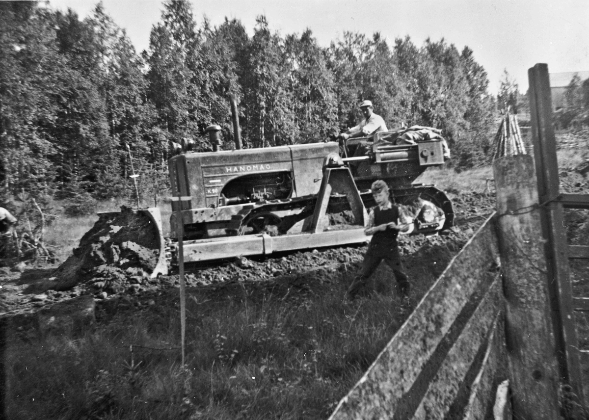 Veibygging Hoelseter – Gresslien i 1954. Oddvar Millidal sitter på bulldozeren. Gutten heter Knut Arne Hjerpseth.