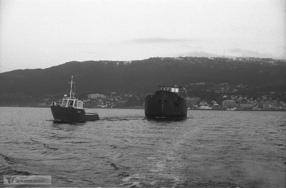 "Bankfisken" til Molde. Bankfisken kom til Molde Torsdag 6 november 1980. Det var kystvaktskipet "Senja" som taua den frå Tromsø og hit. Bilda viser slepinga bort til Hjertøya den 7 november 1980. Ved styrehuset bestyrar Sverre Berg på Romsdalsmuseet.