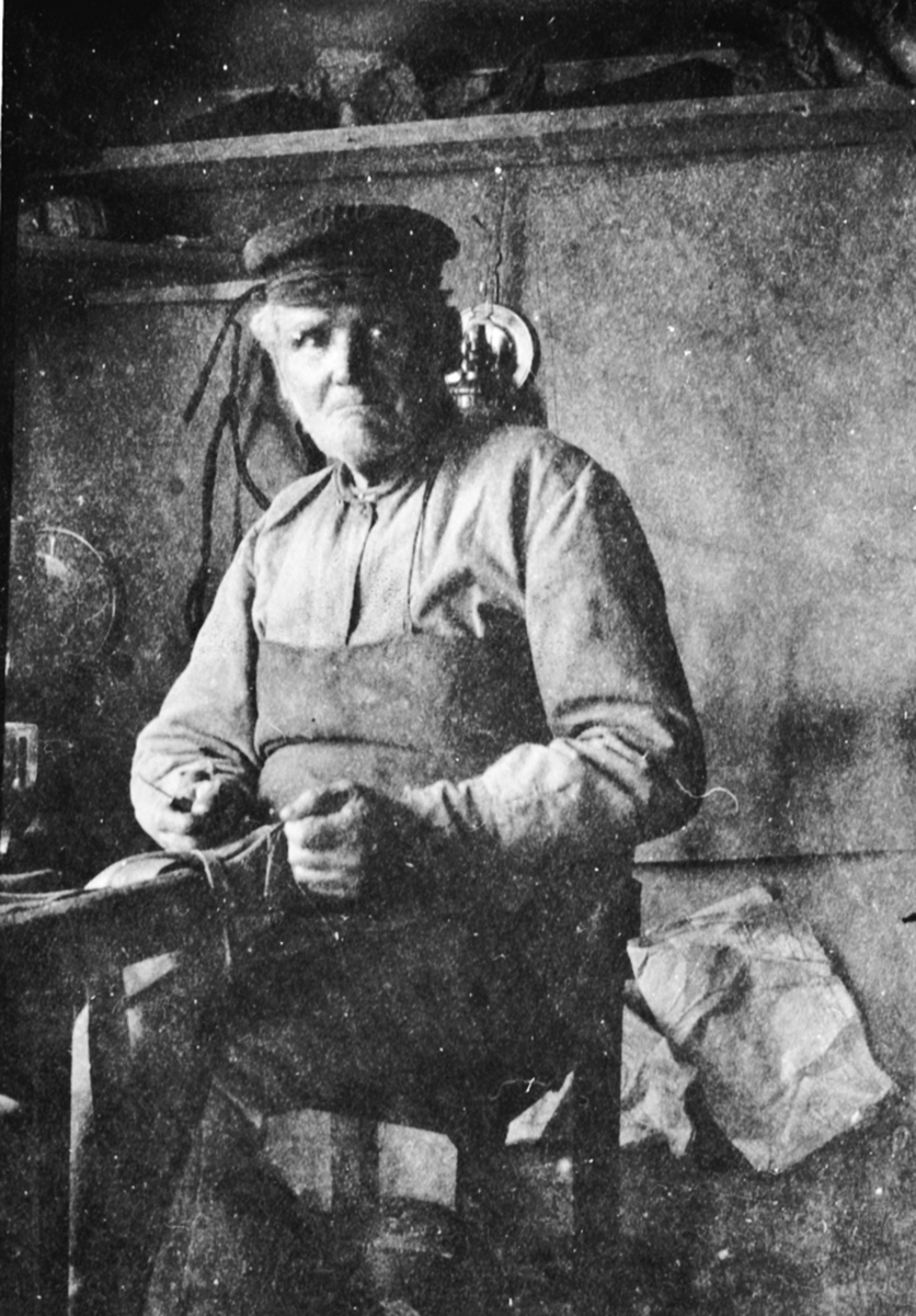 Skomaker Johannes Akselsen (1844-1926) i sitt verksted i Sundby lille, Skredderbakken, Helgøya.