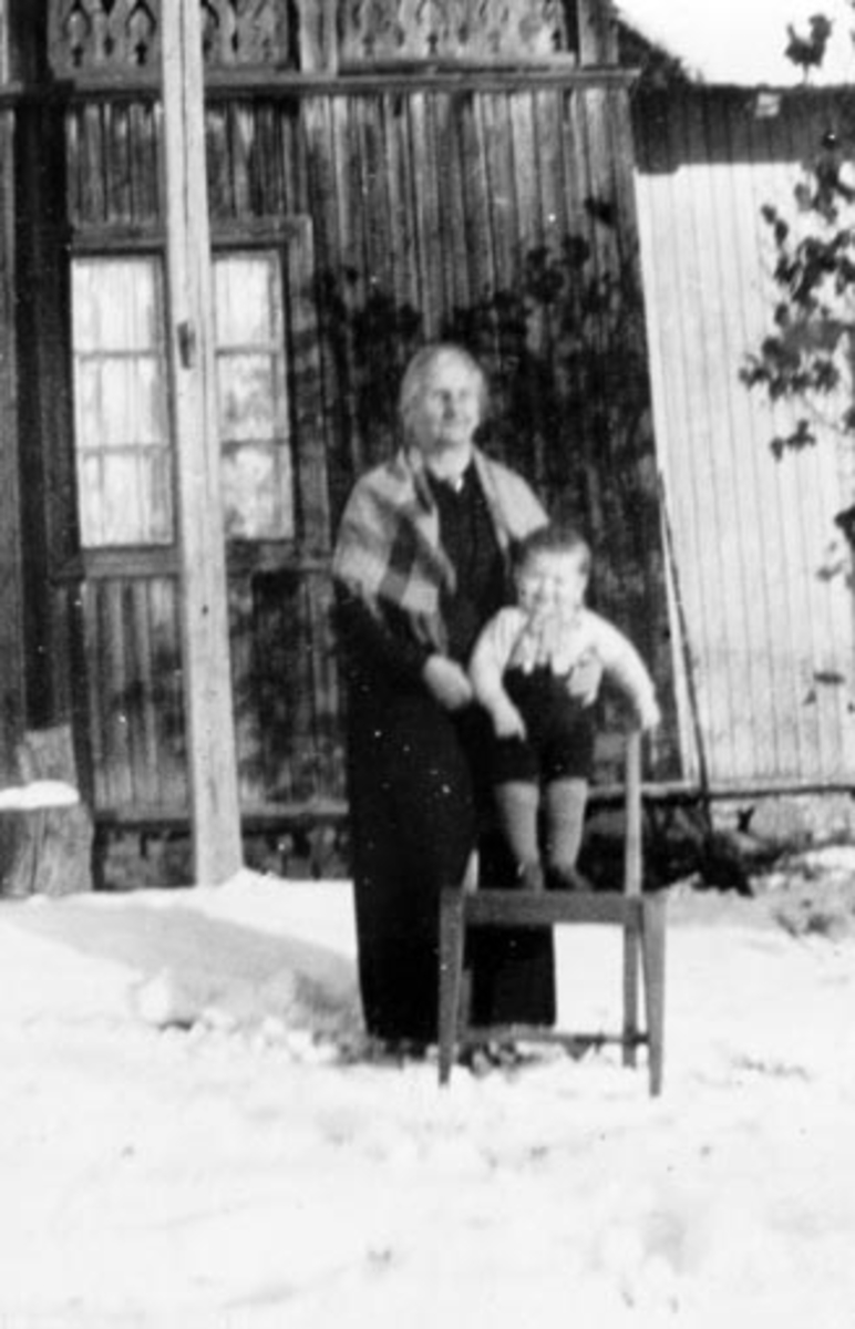 Mathea Grøtlien (1860-1946) med Torbjørn Grøtlien f.1930 på stol foran seg. Østerhagen under Veum, Stavsjø, Hedmark.