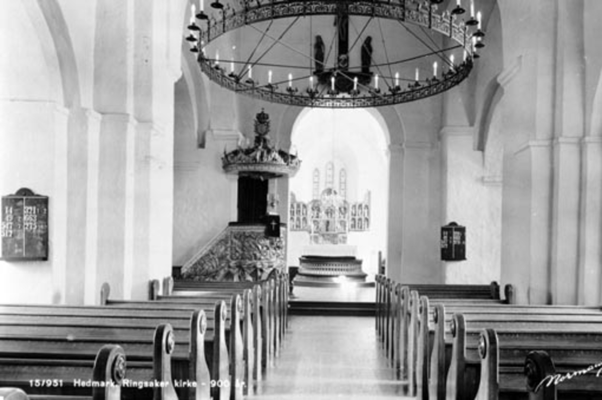 Interiør fra Ringsaker kirke, hovedskipet mot alteret. Gammel lyskrone. Postkort. Sendt 1945.