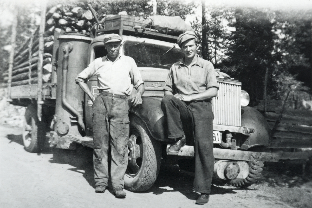 Til Høyre Erling Holstad, til venstre (?) Kristiansen. Chevrolet lastebil med knottgenerator, årsmodell 1937. Lastet med tømmer. 
Bilde er tatt 12. 08-1945 på Løvlia.
