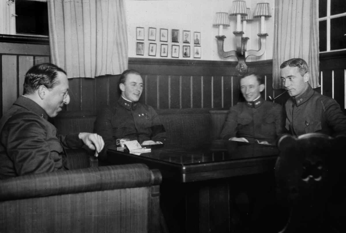 Gruppe 4 militære sittende rundt et bord. Fra venstre: ukjent, Kronprins Olav, Løitnant Eugen Johansen, ukjent. 