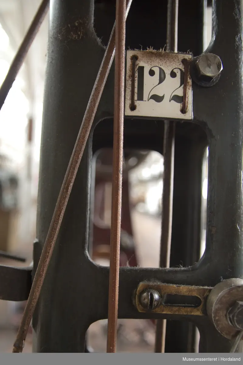 Rundstrikkemaskin med liten diameter frå Schubert & Saltzer Maschinenfabrik i Chemnitz i Tyskland, brukt på Salhus Tricotagefabrik utanfor Bergen. Maskina har berre 16 nåler, to trådar og ein trådførar, og vart truleg brukt til å strikke stay-band som gjorde saumane fastare.

Den har eit handtak på eine sida som ein kan bruke til å sveive maskina manuelt, og eit hjul på denne sida det maskina er kopla til reimdrifta i taket. Maskina har eit lite strykejern som stryk den ferdigstrikka "pølsa" etter kvart som den vert strikka. Strykefunksjonen er kopla til med elektrisk stikkontakt. Er dette ei forbetring som har komme i ettertid? Det kan òg tenkjast at det har vore ei rulle festa til maskina som rulla opp bandet direkte.