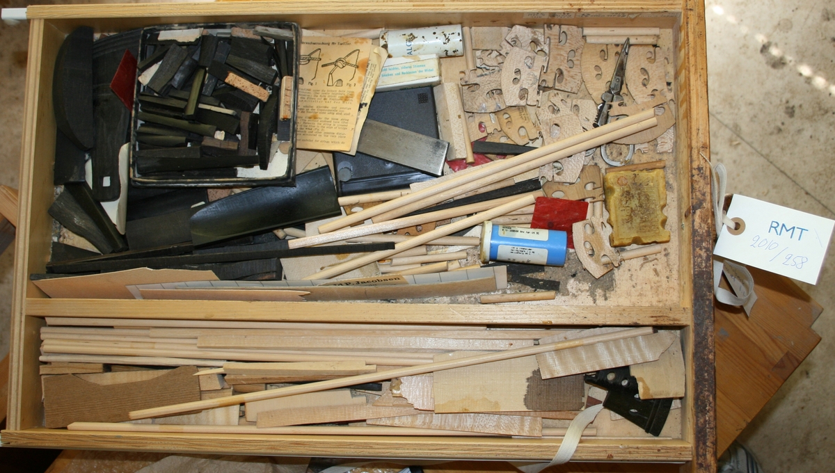 Skuff med diverse verktøy og instrumentdeler: Stol, sadel, lydpinne, med mer.