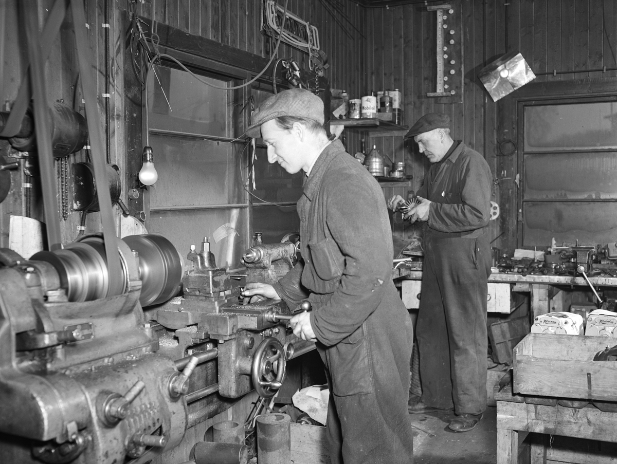 Arnt G. Jensen A/S, rørleggerverksted i Strandgata 53, Hamar. Lastebil D-4652. Ukjente rørleggere på lasteplan på jernbanebrygga. 
Rørleggerfirmaet Arnt. G. Jensen, etablert i 1913 med et par ansatte. Oppdragsmengden i rørleggerbransjen økte raskt i åra som fulgte. I sluuten av 1930 åra hadde firmaet rundt 80ansatte som senere økte til ca. 100 i 1953. Veksten hadde sammenheng med at nye og gamle hus skulle ha innlagt vann, bad og klosetter. Firmaet installerte også sentralfyr med fyrkjel og radiator. De påtok seg også ventilasjonsoppdrag. 
Se opplysninger om firmaet i "Hamars Næringsliv i jubileumsåret 1949" 
"Fra Kaupang og bygd 2010"
"Glimt fra Hamar Håndverkerforenings historie fra 2003"