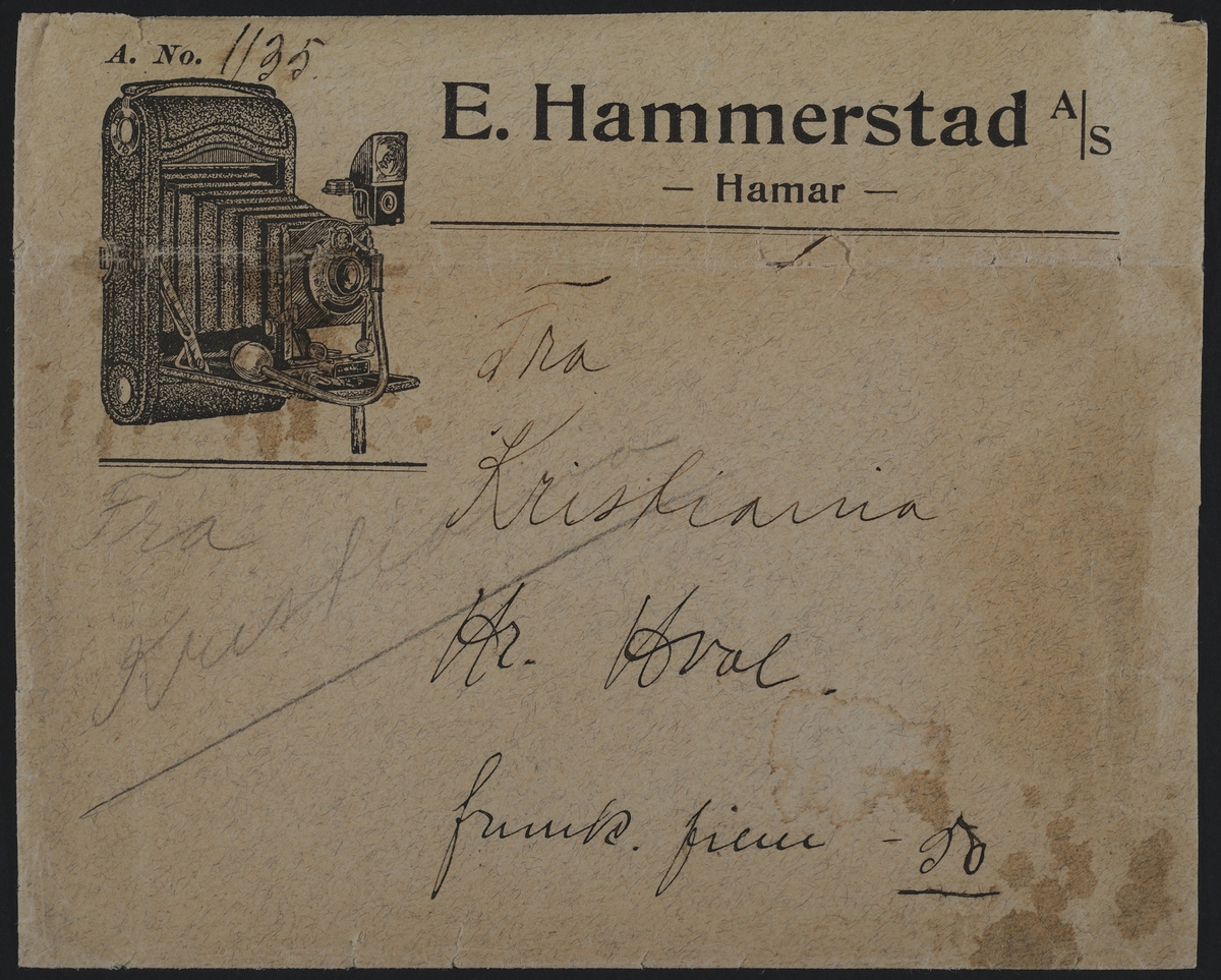 Fotokonvolutt. E. Hammerstad A/S Hamar. 
E. Hammerstad -optiske artikler, sykepleierartikler-fotografiske artikler - og parfymeri. 
"E. Hammerstad startet sin forretning som optisk instrumentmaker og metallstøper i 1862 og fra 1868 var han også bandagist og fra 1877 justermester. Han drev sin forretning til den i oktober 1910 ble overtatt av urmaker A. M. Sveen og gullsmed P. Børke, og ved Sveens død gikk overrettsakfører Hjelmstad inn som medeier. I. juni 1918 ble forretningen overtatt av et aksjeselskap bestående av Trygve S. Hansen. Moriitz Hansen og S. Christiansen, med den første som disponent. Fra november 1928 driver Trygve S. Hansen forretningen som eneinnhaver. Hansen var utdannet som gullsmed, men etter at han hadde arbeidet som sådann en tid i Amerika, skaffet han seg seg spesiallutdannelse som optiker ved optikerkurser i Tyskland. Etthvert ble forretningen utvidet til å omfatte fotografiske artikler med kopieringsantalt og parfymeri. "
Sitat fra "Hamars næringsliv i jubileumsåret 1949"