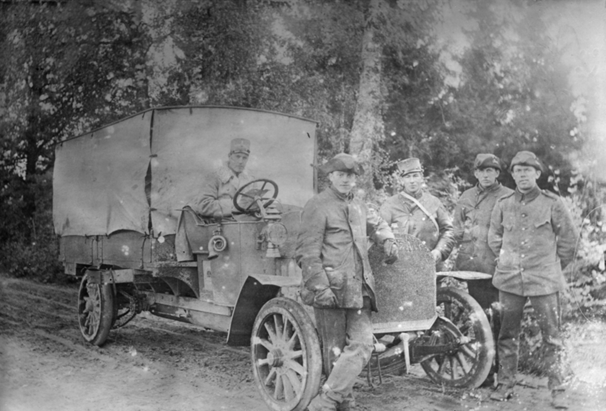 Porträtt av fem män vid en bil på Flygkompaniet på Malmen.