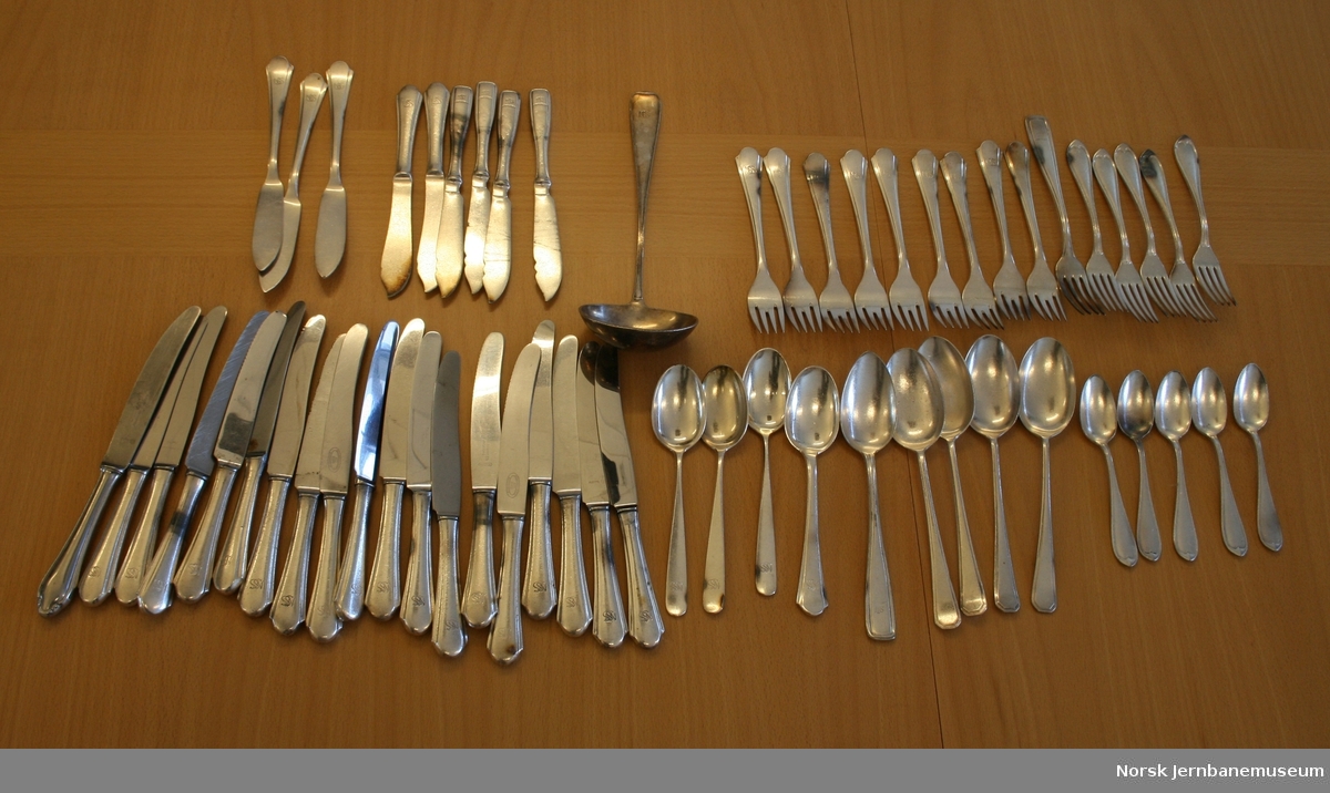 Spisebestikk, de fleste med "NSS" logo (Norsk Spisevognselskap), bestående av: 
19 kniver, 6 kniver til fisk, 3 smørkniver, 15 gafler, 9 suppeskjeer, 5 teskjeer og 1 suppeøse.
Alt bestikket er merket NM 90, som betyr 90 grams forsølving (Hotellplett).