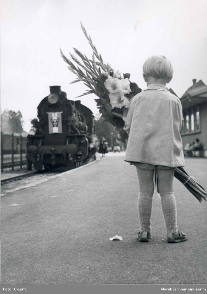 Barn med blomster hilser toget ved jernbanejubileet