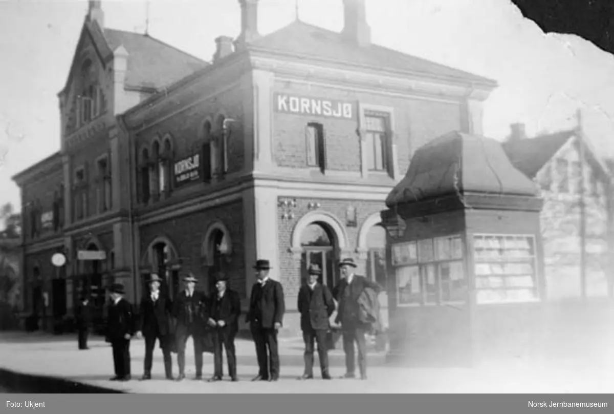 Kornsjø stasjonbygning med en oppstilt gruppe i forgrunnen