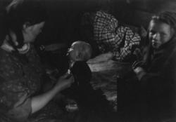 Kautokeinofamilie, en kvinne og to barn i et rom. Kautokeino
