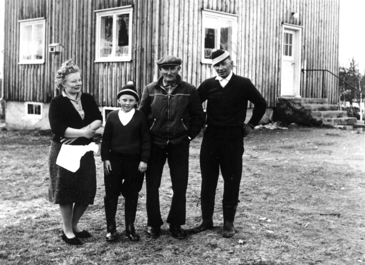 Portrett av Klemet og John Jonassen med husholderske og reingjeter foran et våningshus, 1961.