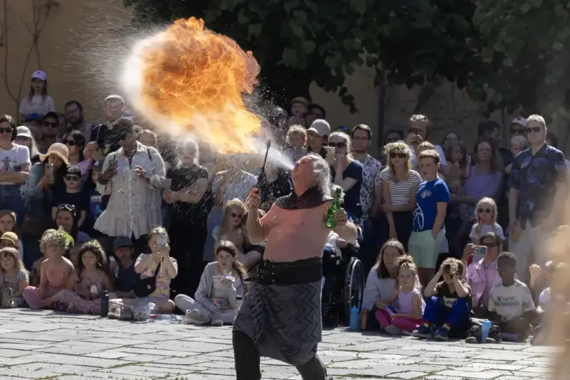 Performer from Stella Polaris breathing fire in front of an audience at the Midsummer Festival at Norsk Folkemuseum.